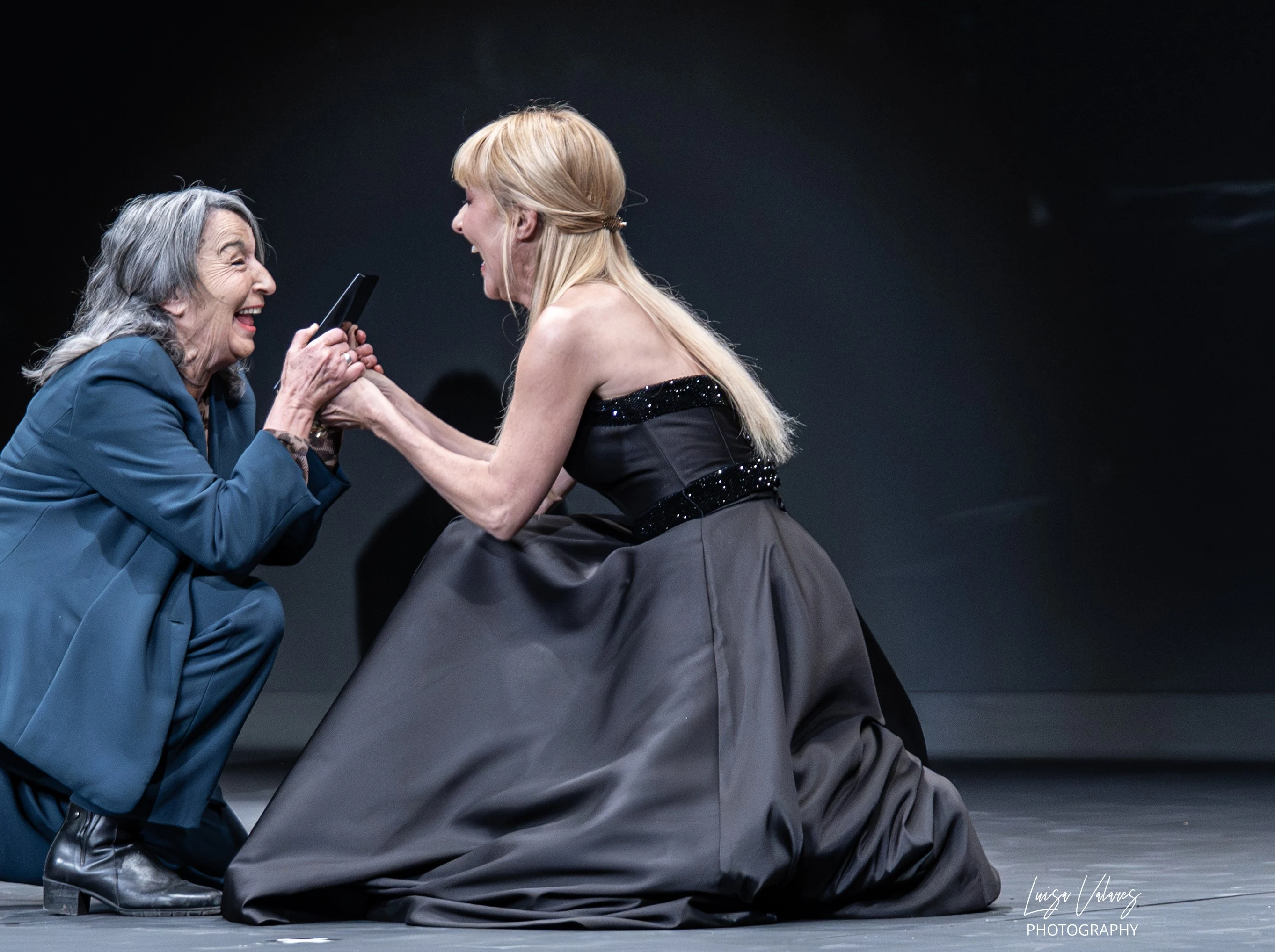 Dos actrices se toman de las manos, arrodilladas sobre el escenario, en la gala de las Medallas de Oro de la Academia de las Artes Escénicas. Foto de Luisa Valares